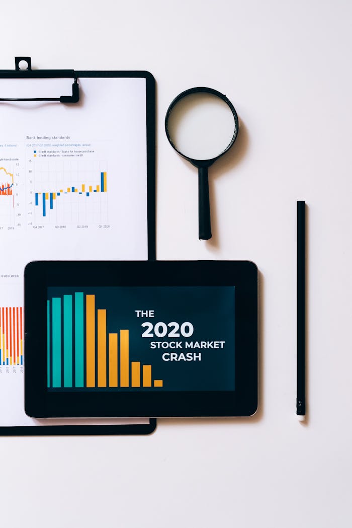Tablet displaying 2020 stock market crash with graphs and analytics tools on desk.